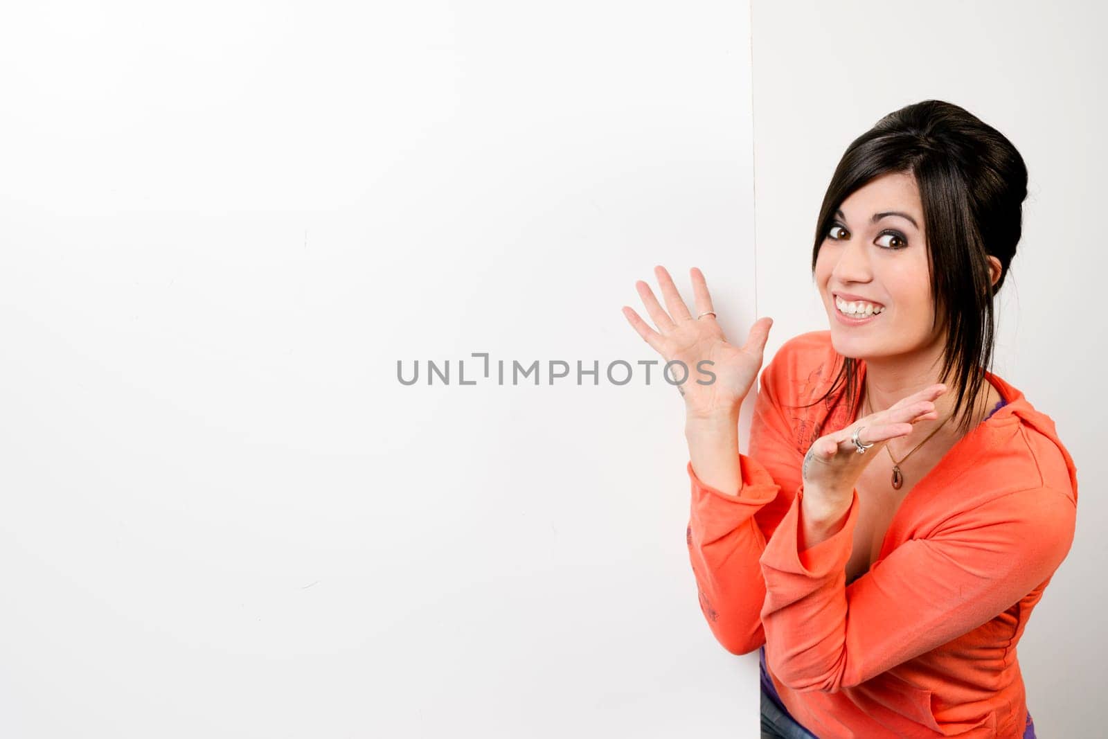 Very excited woman stands next to blank white space