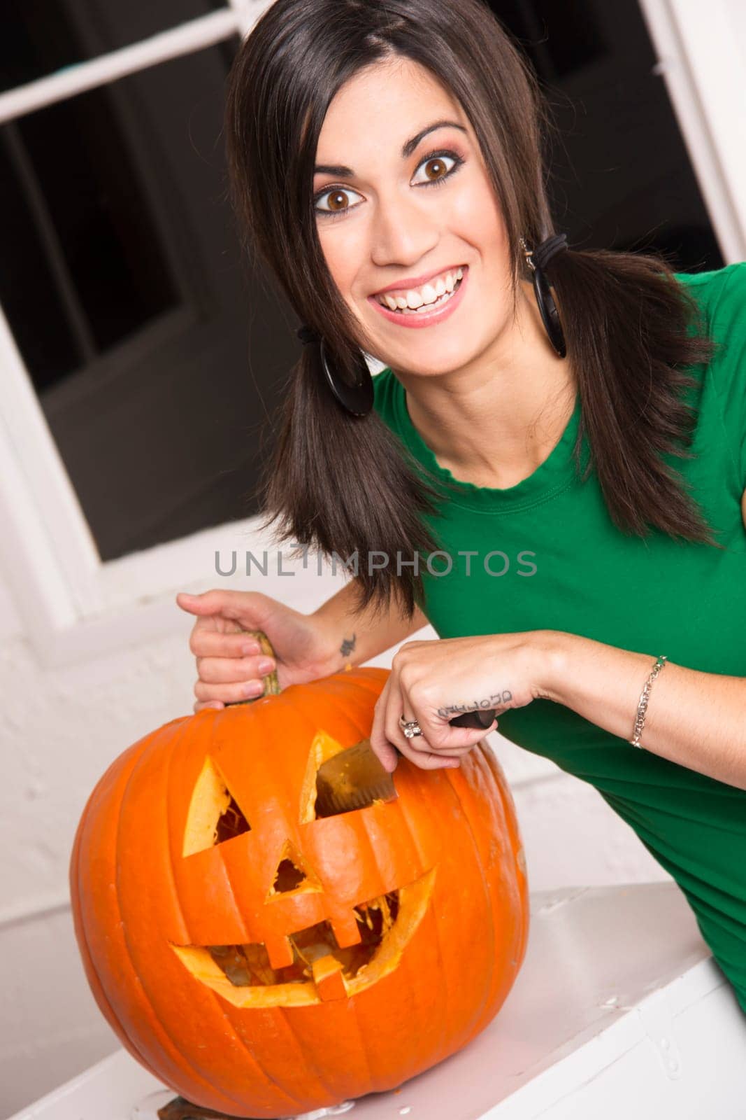 Excited woman prepares Halloween Pumkin carving it with a knife