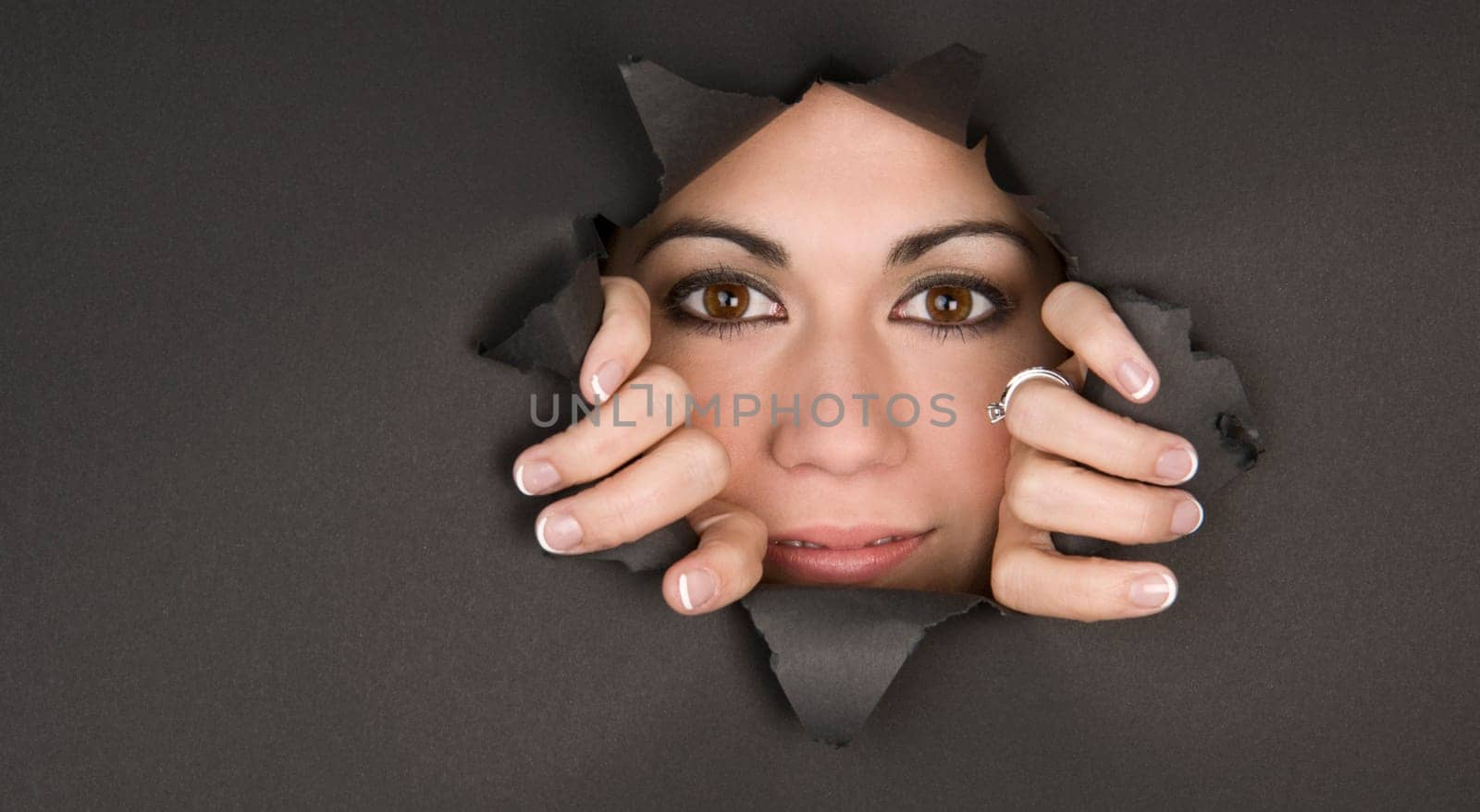Bright Eyed Woman breaks through a hole and looks inside