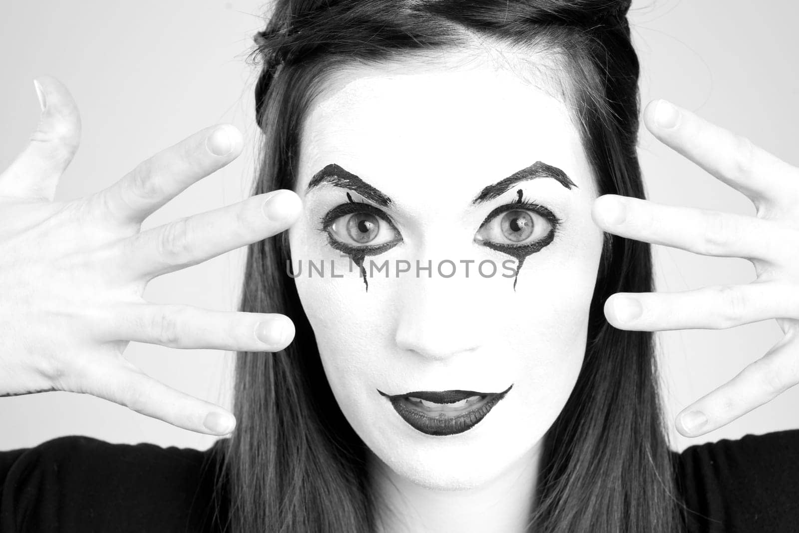 Clown Mime in Whiteface Looking through her fingers