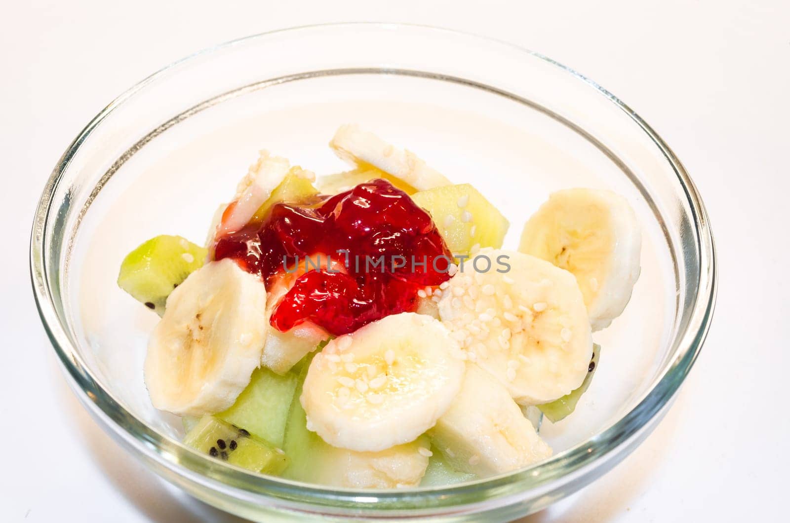 Close-up glass bowl with fresh fruit,with bananas,strawberries,kiwis.........