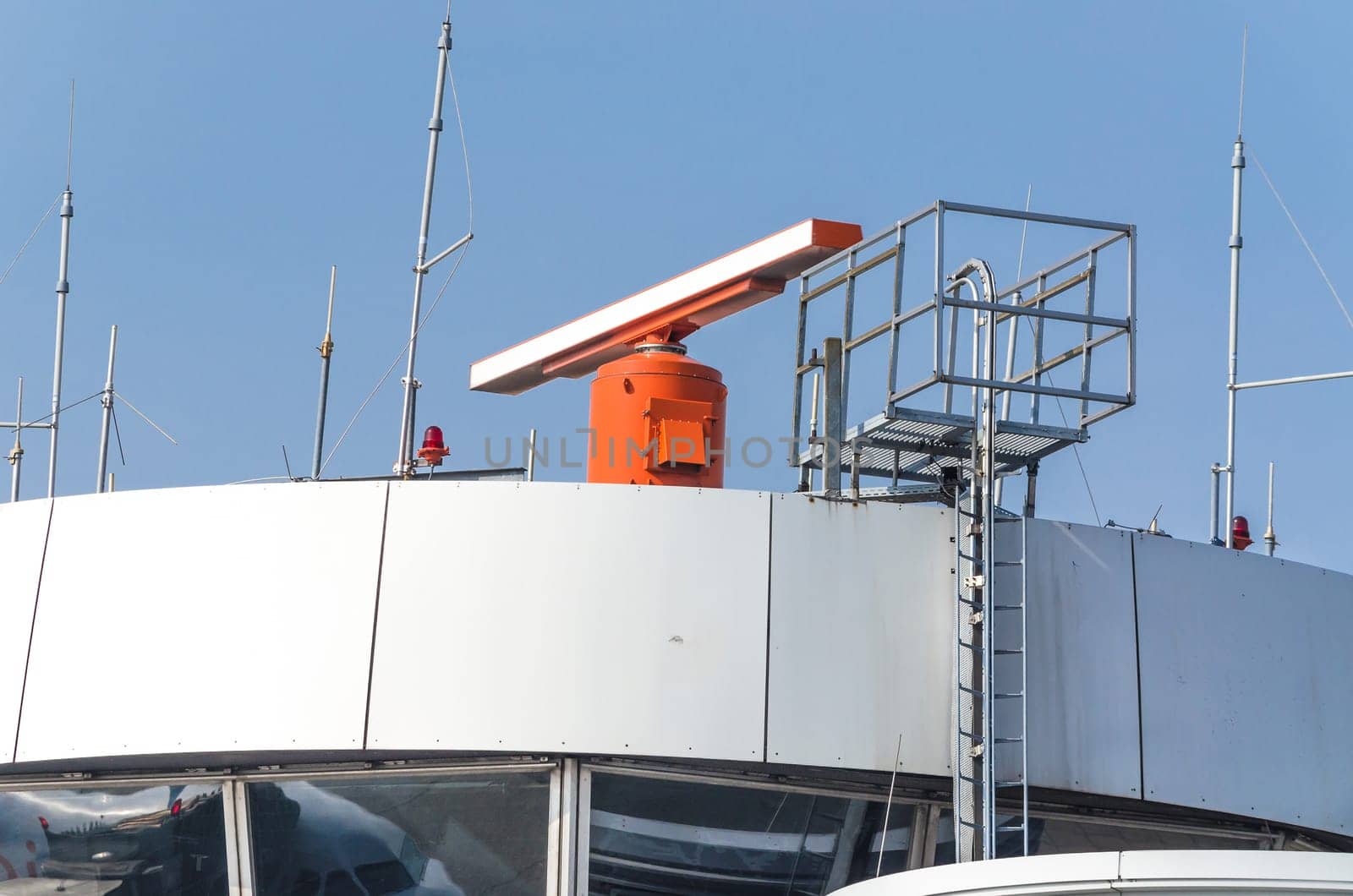 Air traffic control tower with radar system at an airport.
