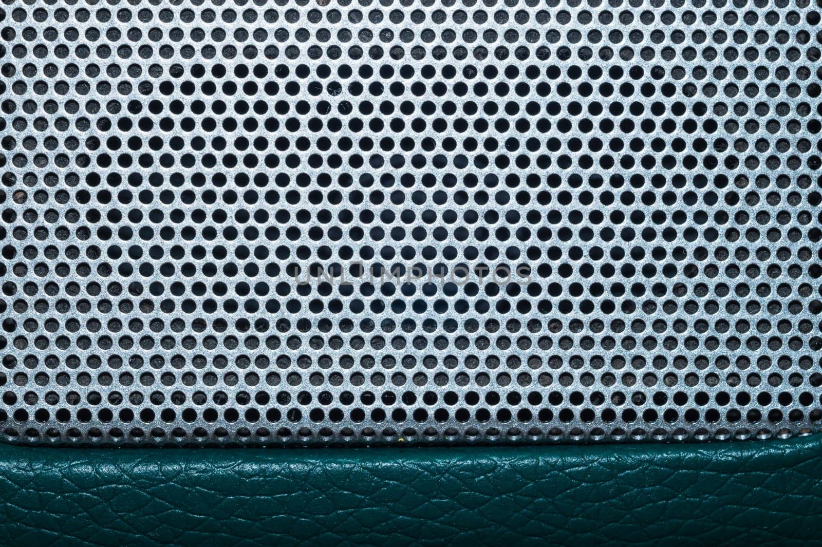 Grid of speaker with round holes. gray protective mesh