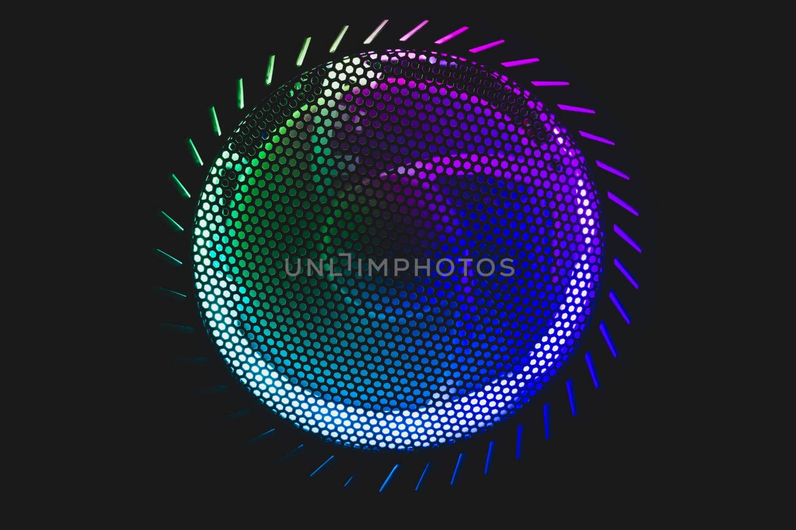 Colorful led lights of computer fan shines through the protective grid. illumination glows in the dark. abstract futuristic background