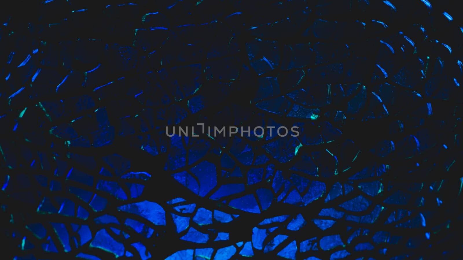 Shattered transparent glass pattern in the dark. abstract cracked background. blue splinters