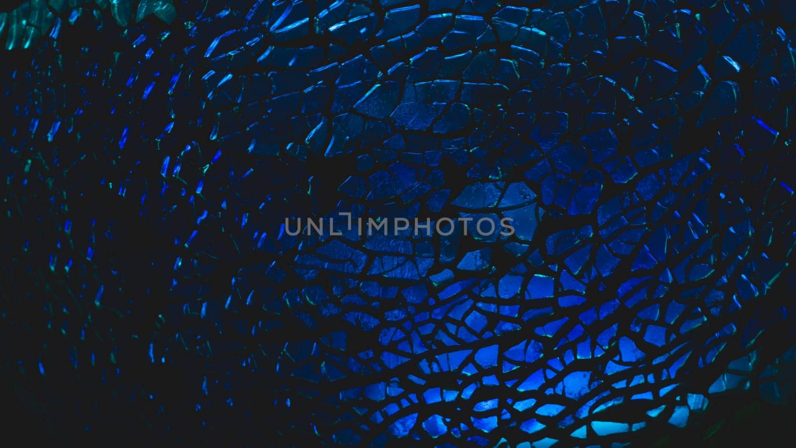 Shattered transparent glass pattern in the dark. abstract cracked background. blue splinters