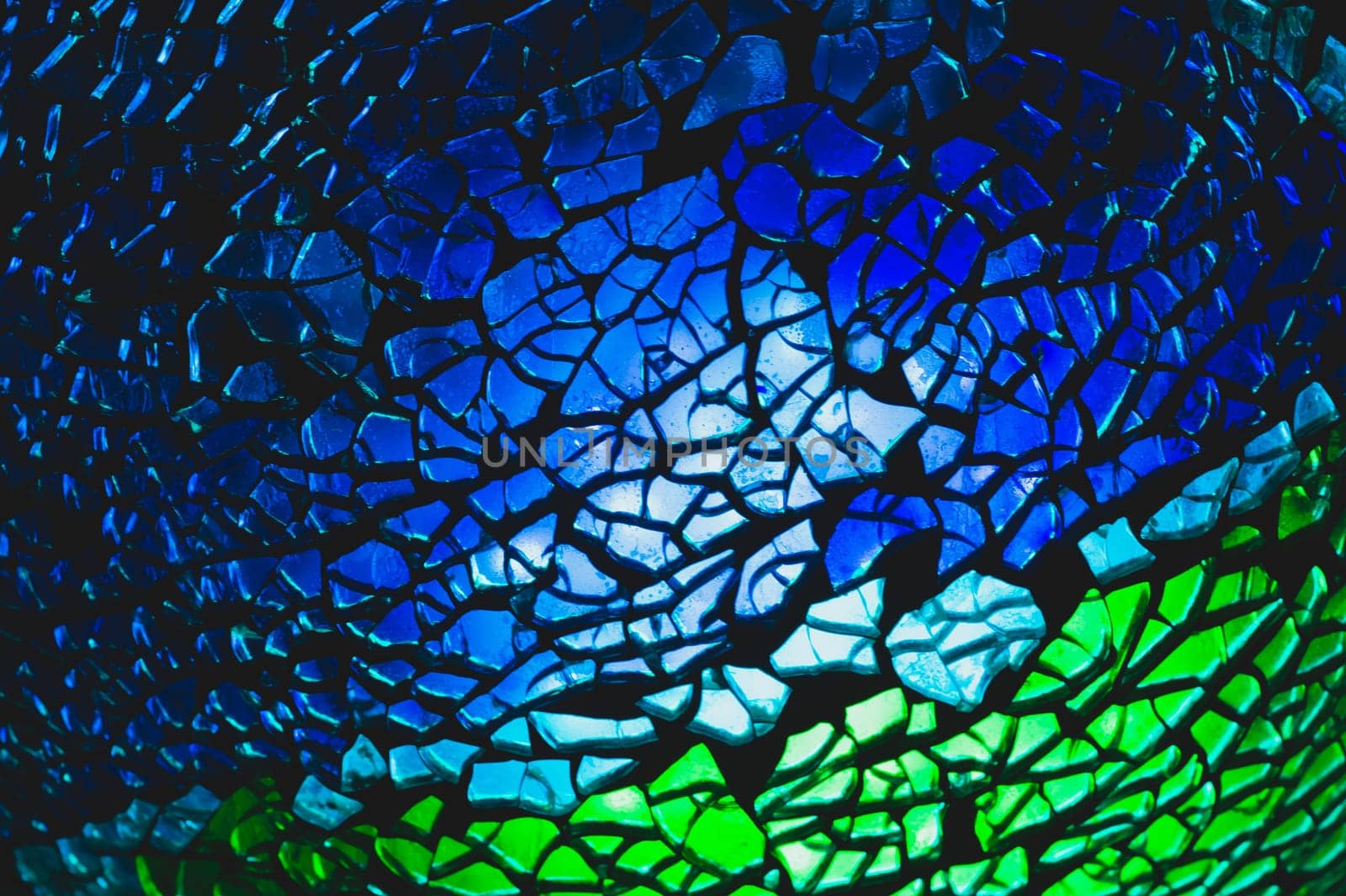 Shattered glass pattern in the dark. abstract cracked background. green and blue fragments