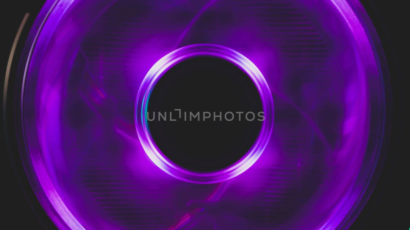 Violet light of computer cooling fan close up. cooler in action with leds. abstract background. power in motion concept