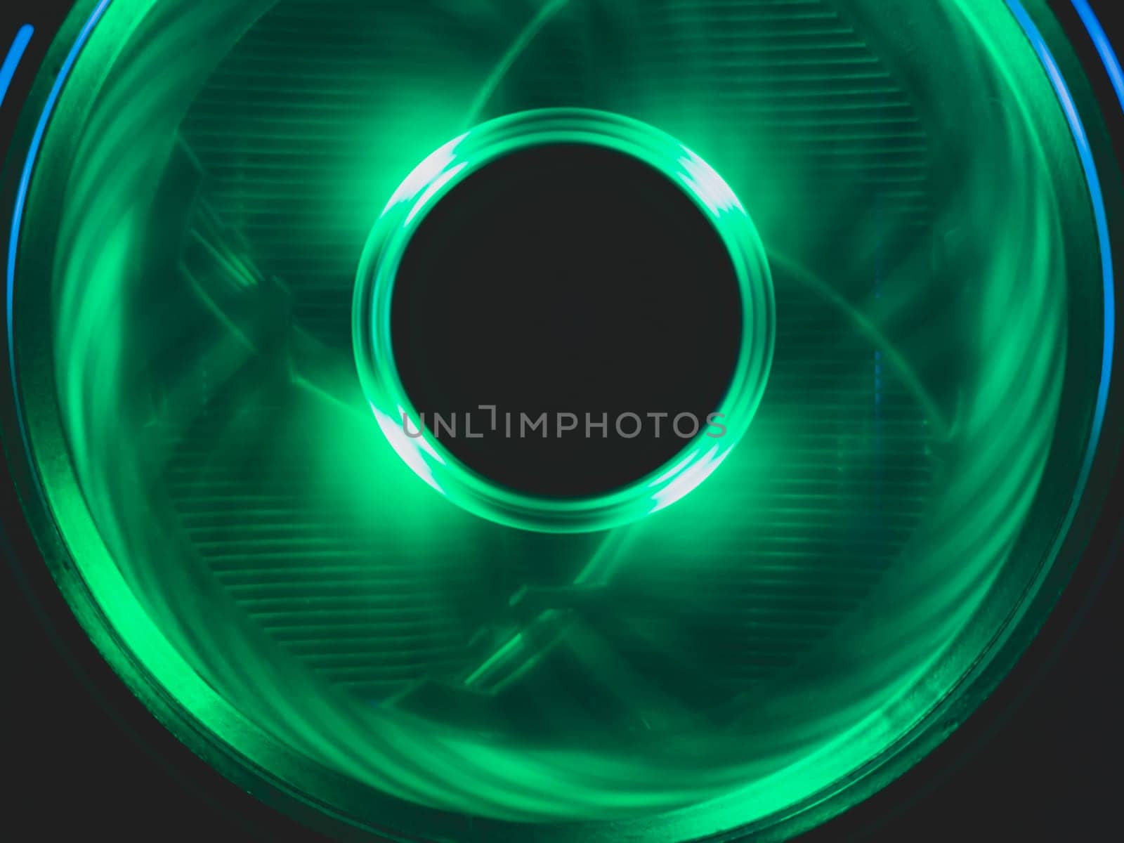 Computer fan with green light close up. cooler in action with leds. power in motion concept. abstract background. round copy space in the middle