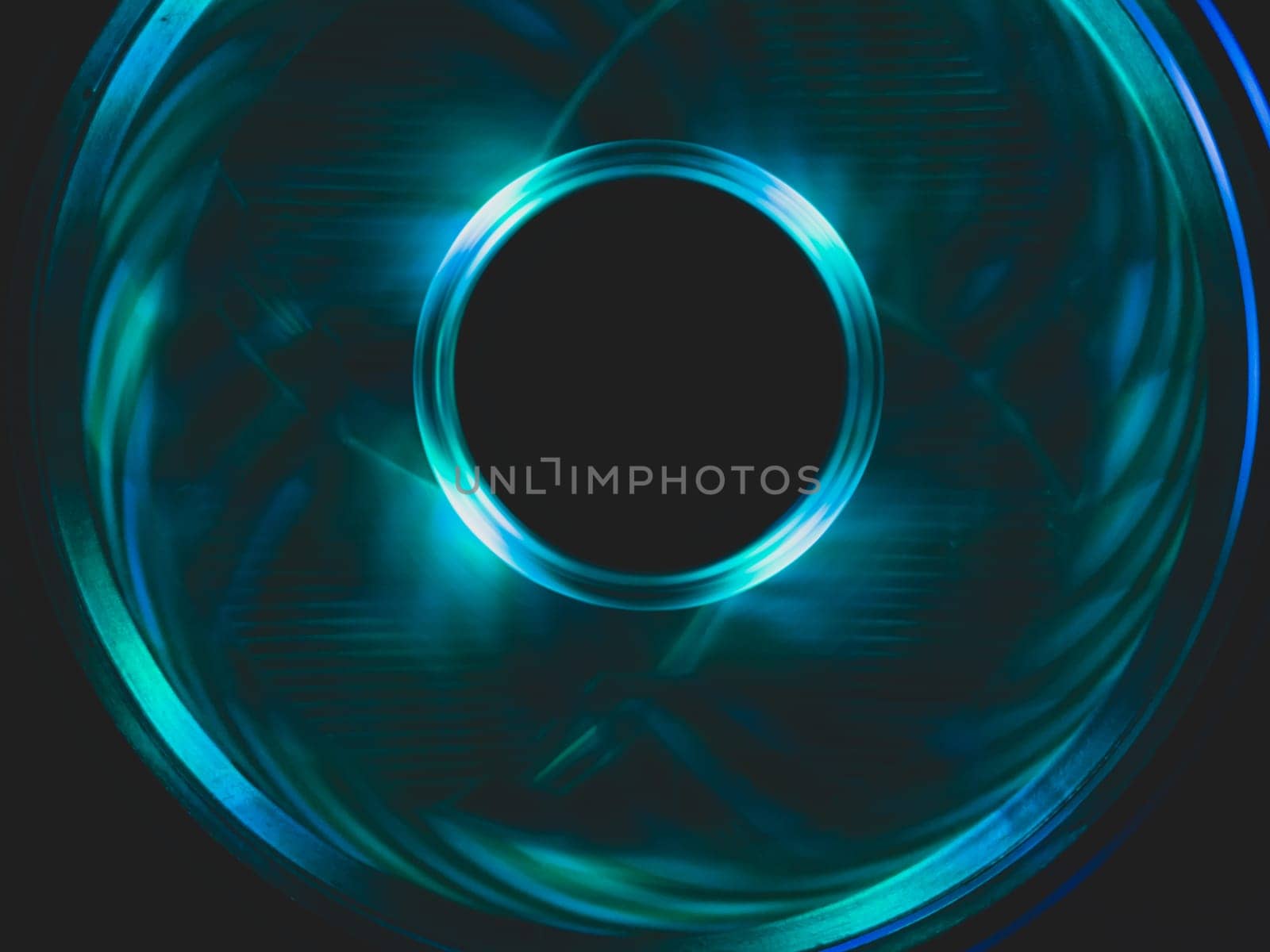 Computer fan with blue light abstract background. cooler in action with led close up. power in motion concept