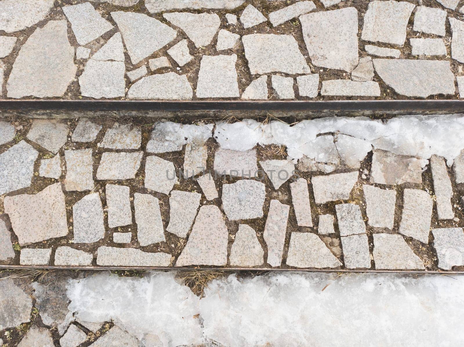 Melting snow on cobblestone pavement steps