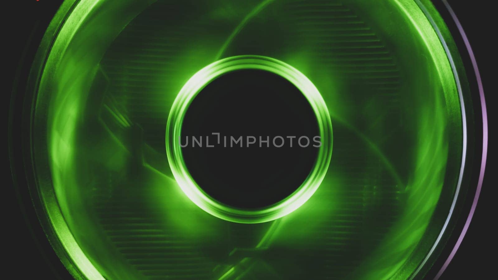 Computer cooling fan with green light close up. cooler in action with leds. power in motion concept. abstract background