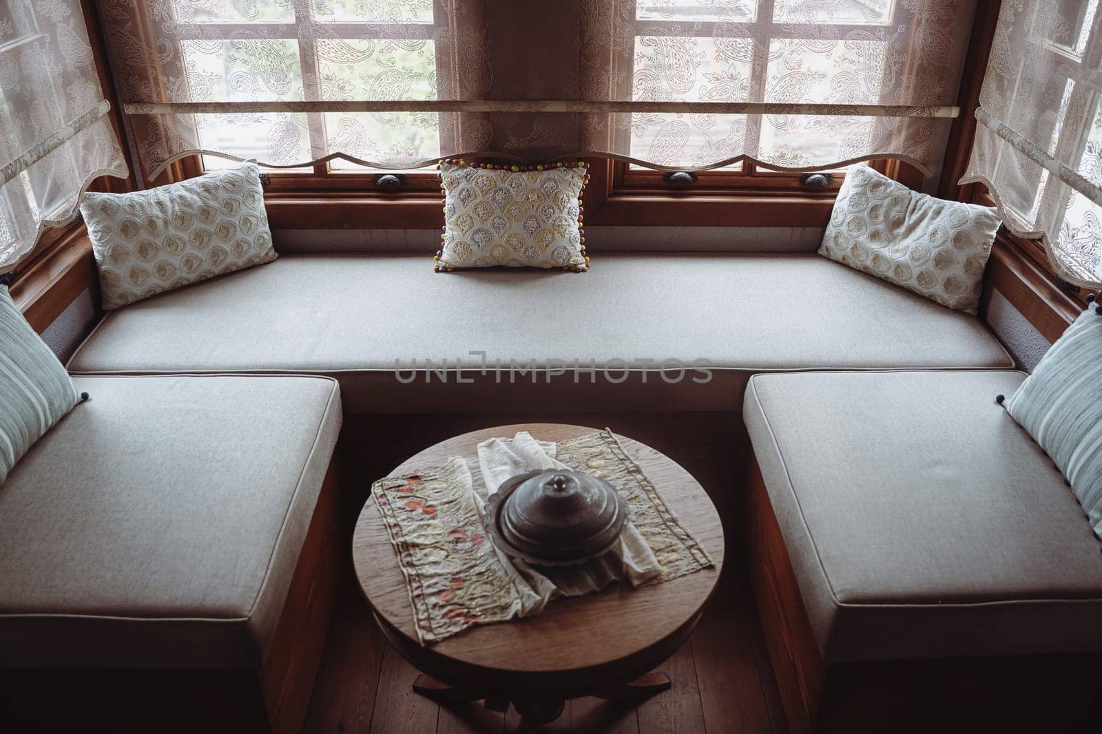 top view of divan with several pillows in front of window