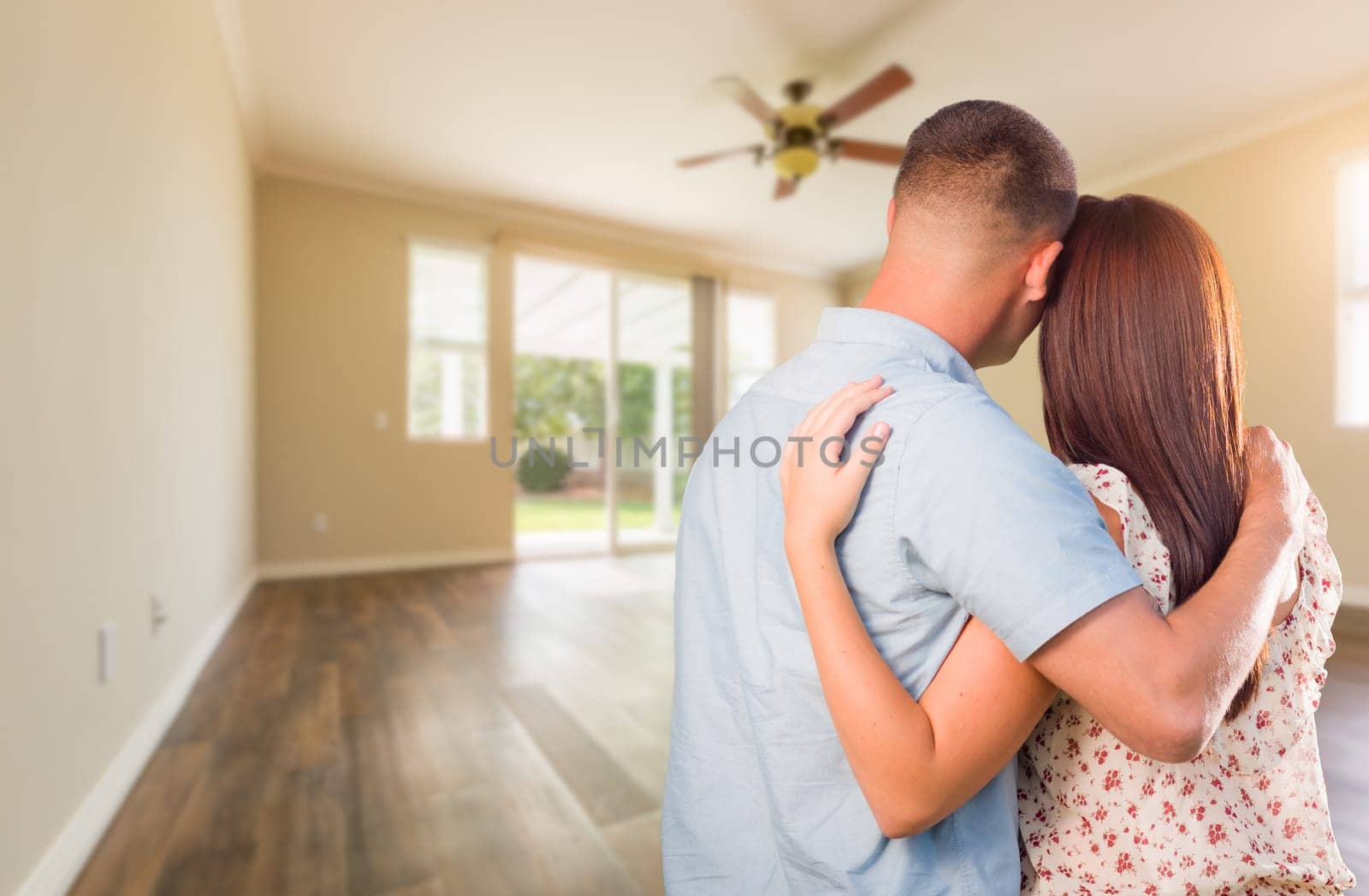 Young Military Couple Looking At Empty Room of New House.