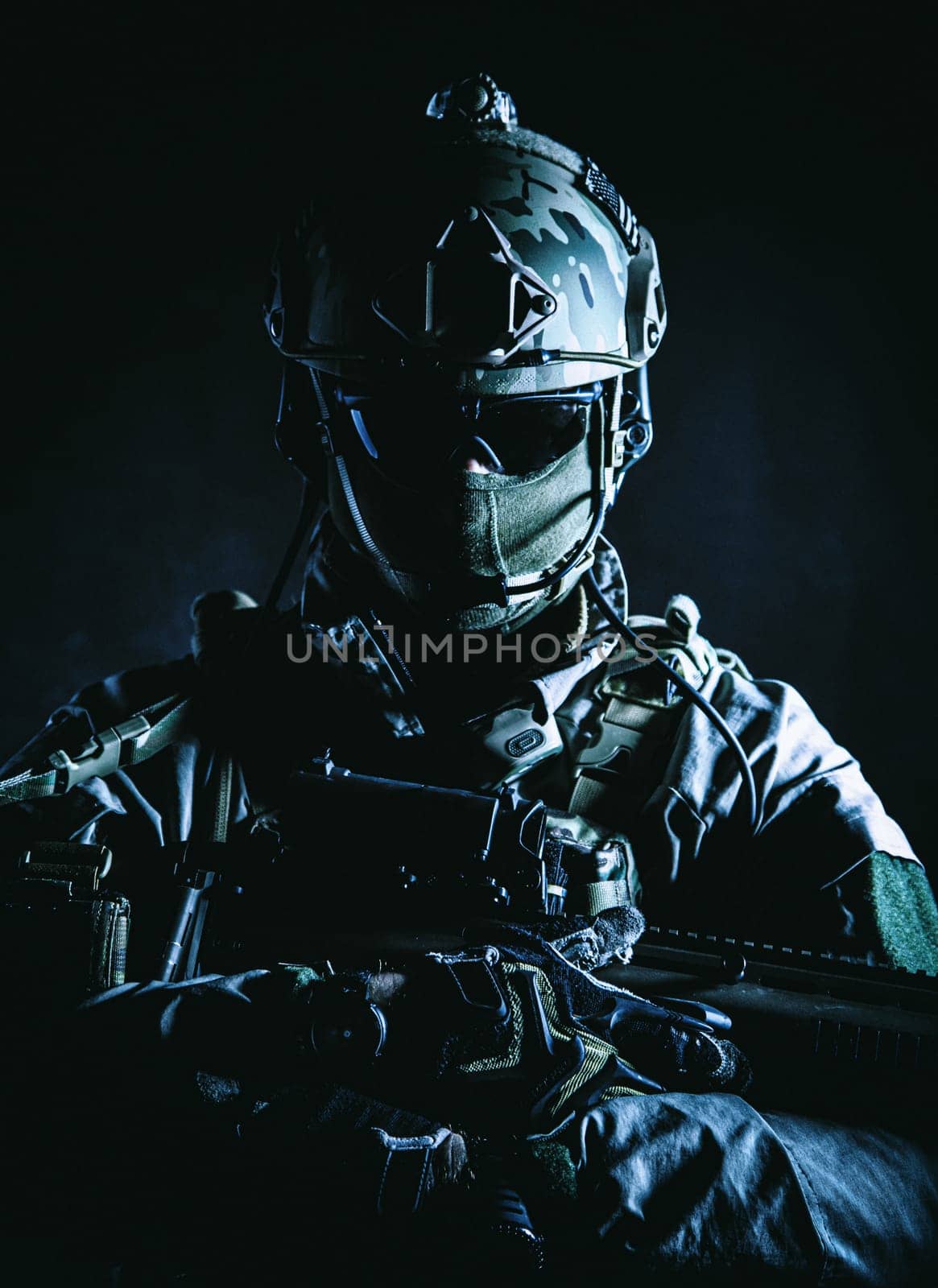 Army soldier in Protective Combat Uniform holding Special Operations Forces Combat Assault Rifle. Studio shot, dark contrast, cropped, black dark background, contour shot