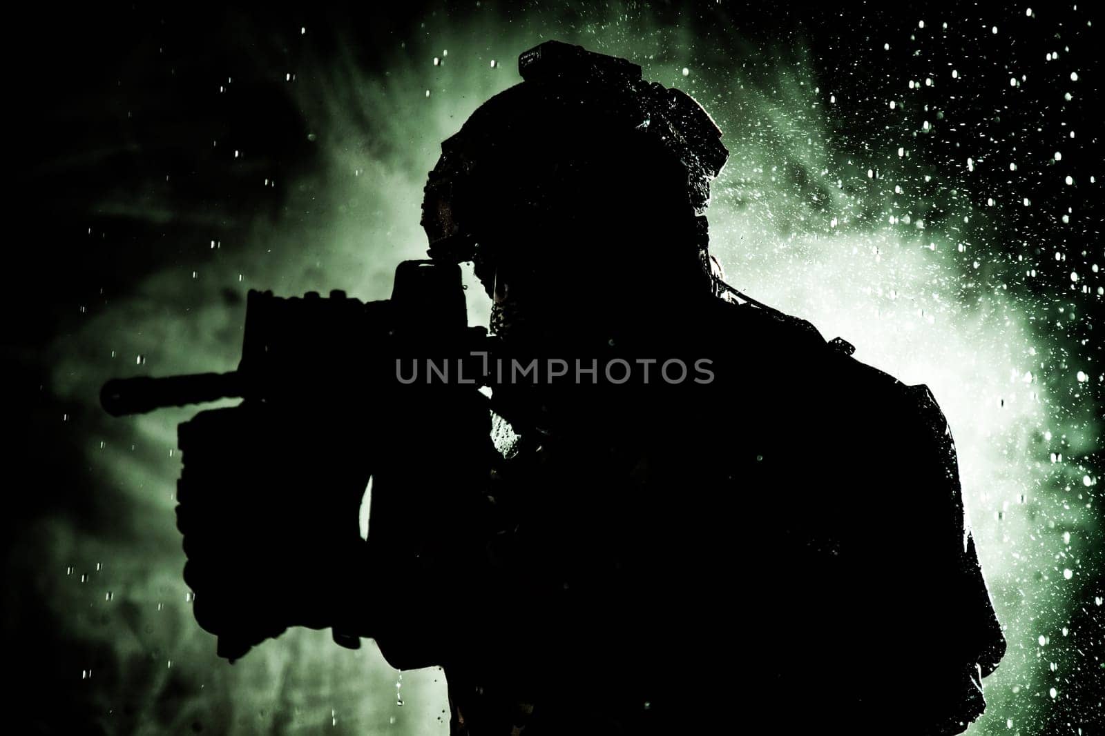 Anti terrorist squad fighter, army special forces rifleman in battle uniform, tactical radio headset, backpack, body armor, aiming service rifle with collimator sight, sneaking in darkness under rain in the dakrness, silhouette in the dark