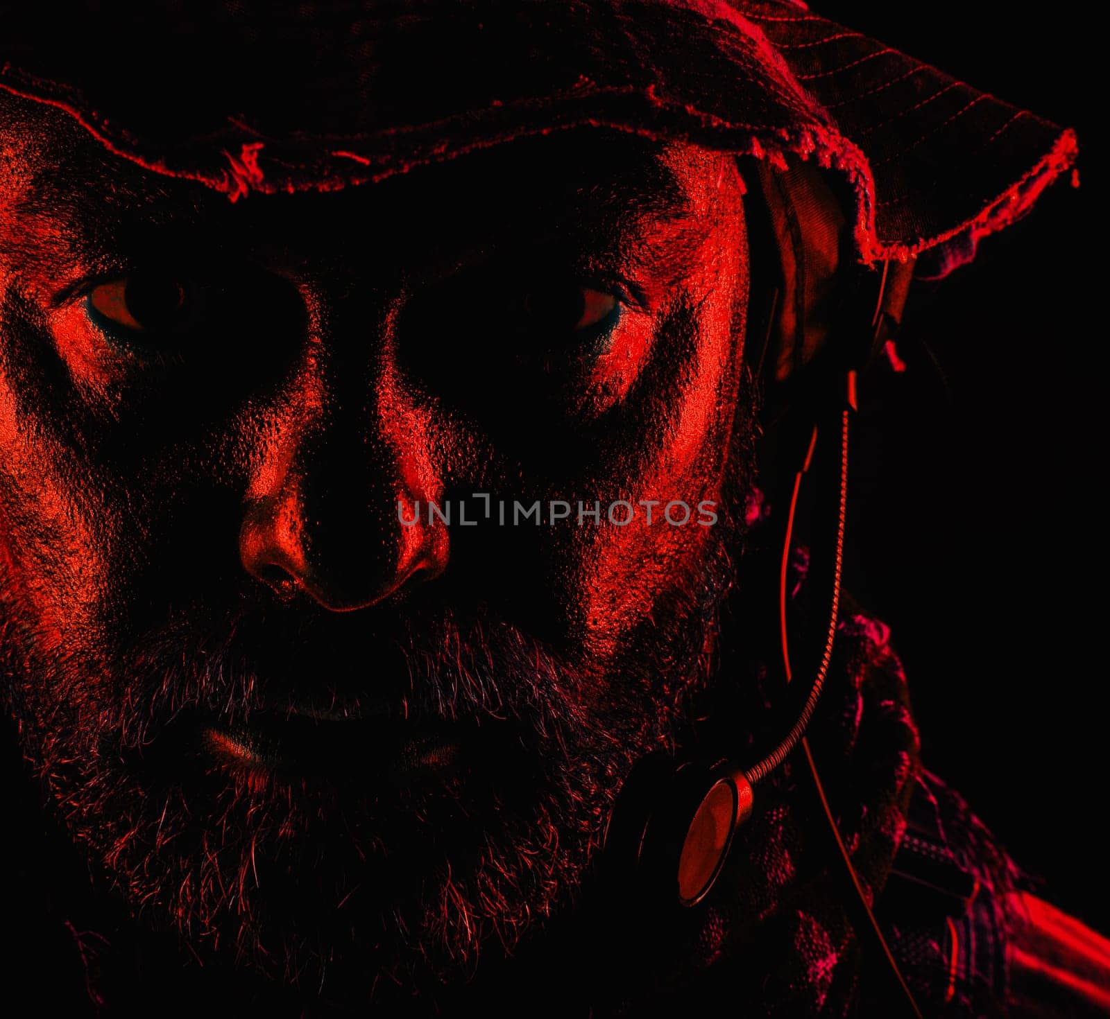 Special forces United States in Camouflage Uniforms studio shot. Wearing jungle hat, Shemagh scarf, painted face. Black background, bottom light colorized toned contour shor
