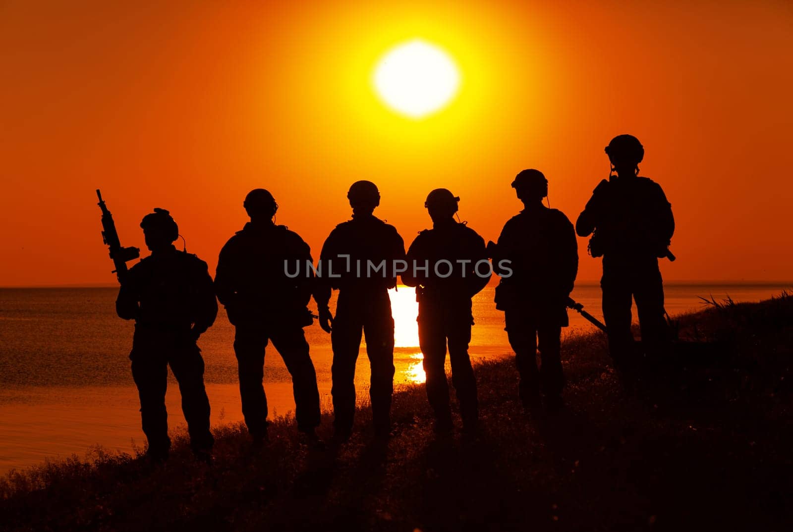 Army soldiers with rifles orange sunset silhouette