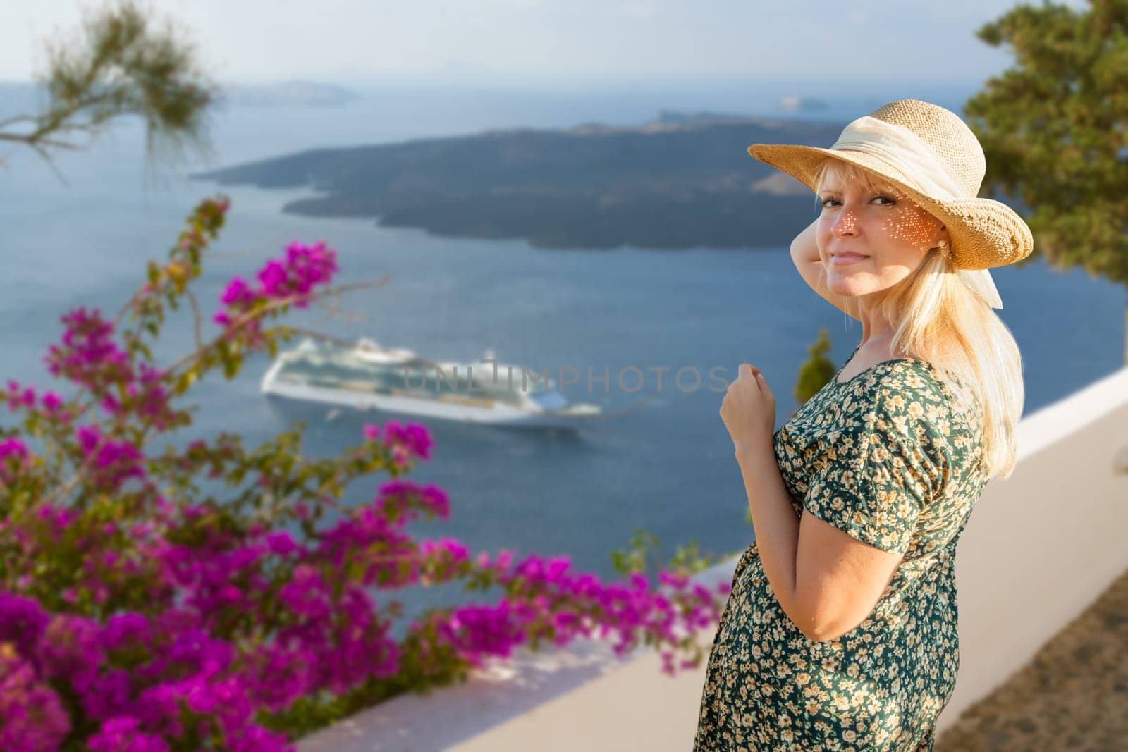 Female Tourist Off the Coast of Santorini Greece Looking Back At Camera.