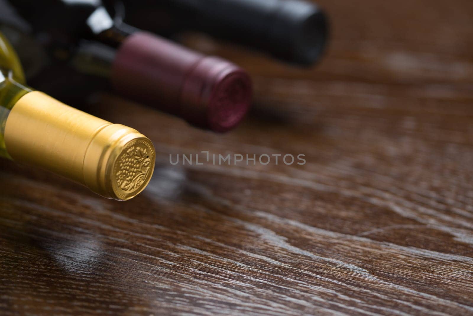 Various Wine Bottles on a Reflective Wood Surface Abstract.