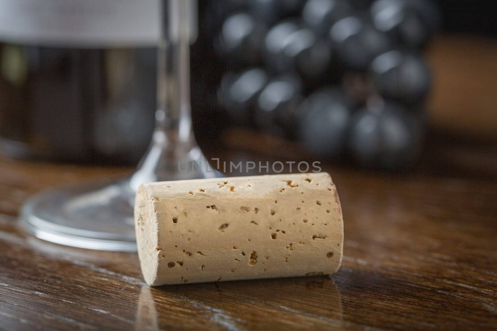 Blank Wine Cork Resting on Wood Table Near Grapes, Bottle and Glass.