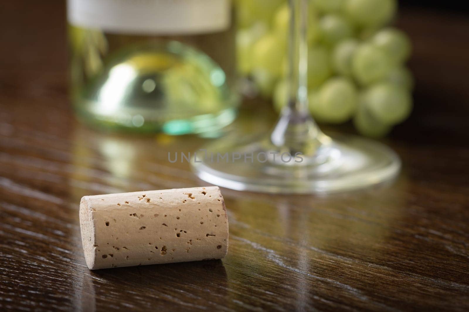 Blank Wine Cork Resting on Wood Table Near Grapes, Bottle and Glass.
