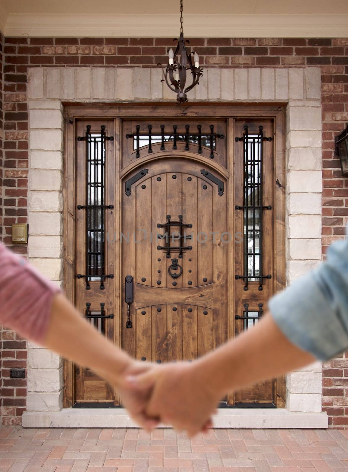 Couple Holding Hands Approaching Front Door of House.