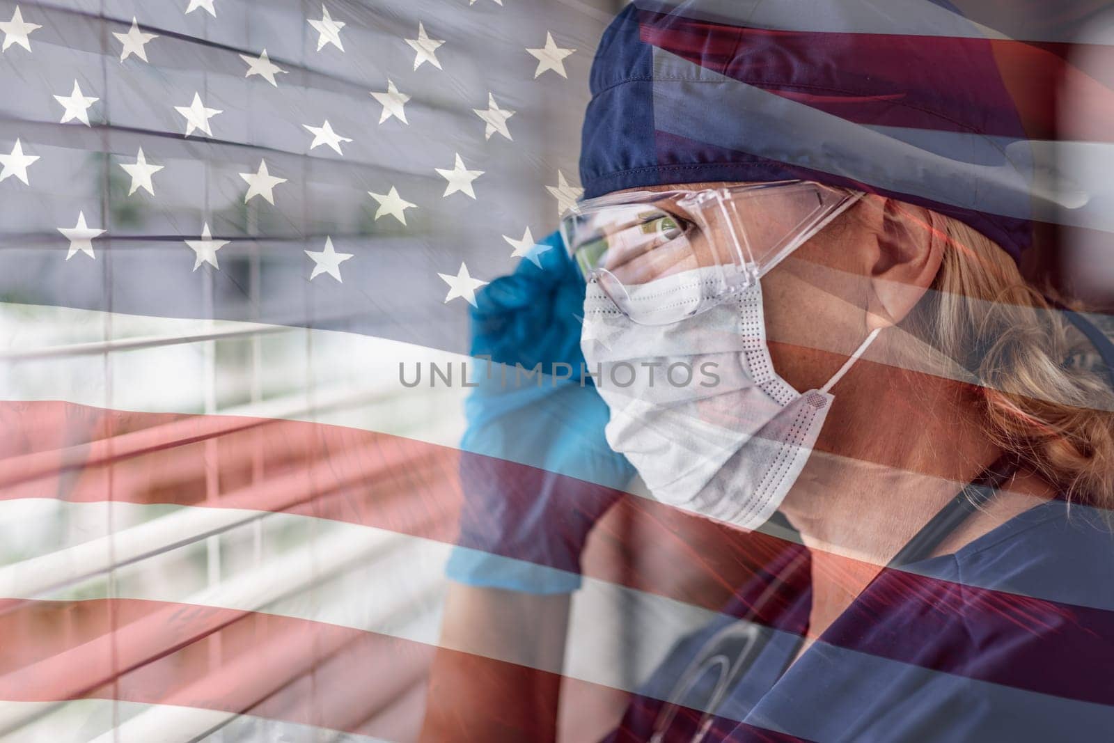 Stressed Female Doctor or Nurse On Break At Window Wearing Medical Face Mask and Goggles With Ghosted American Flag.