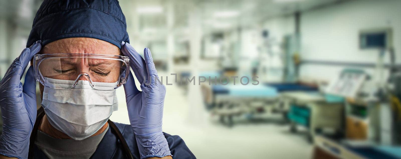 Stressed Doctor or Nurse Wearing Medical Personal Protective Equipment (PPE) Within Hospital.