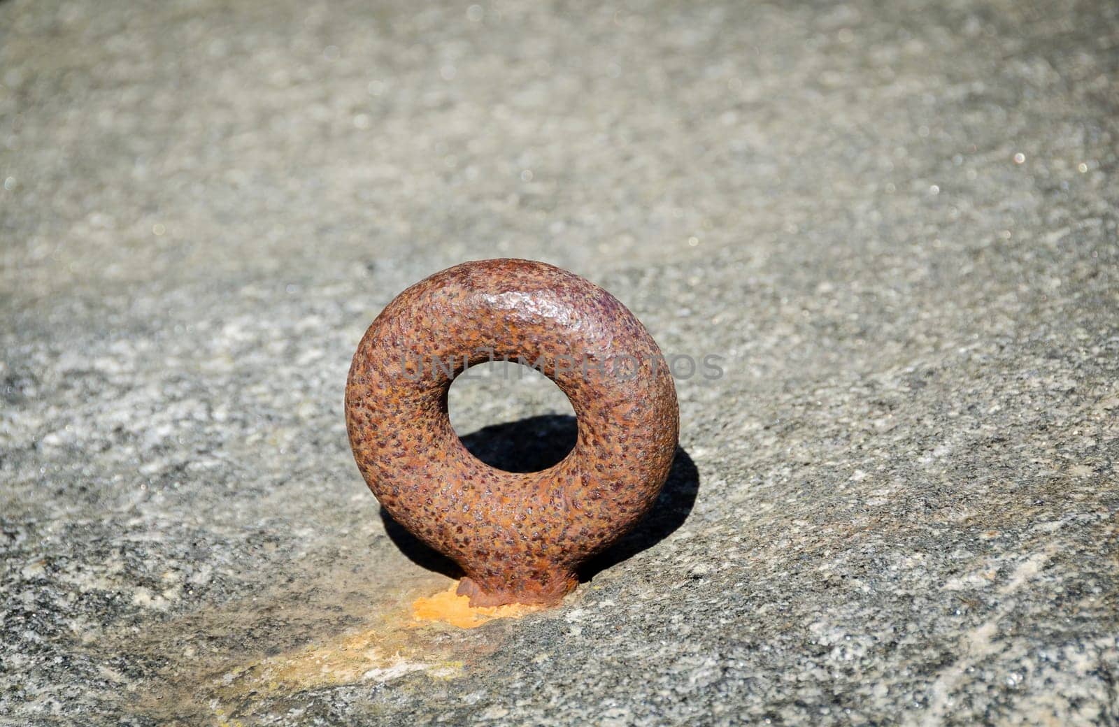 one rusty mooring loop for boat on the rock