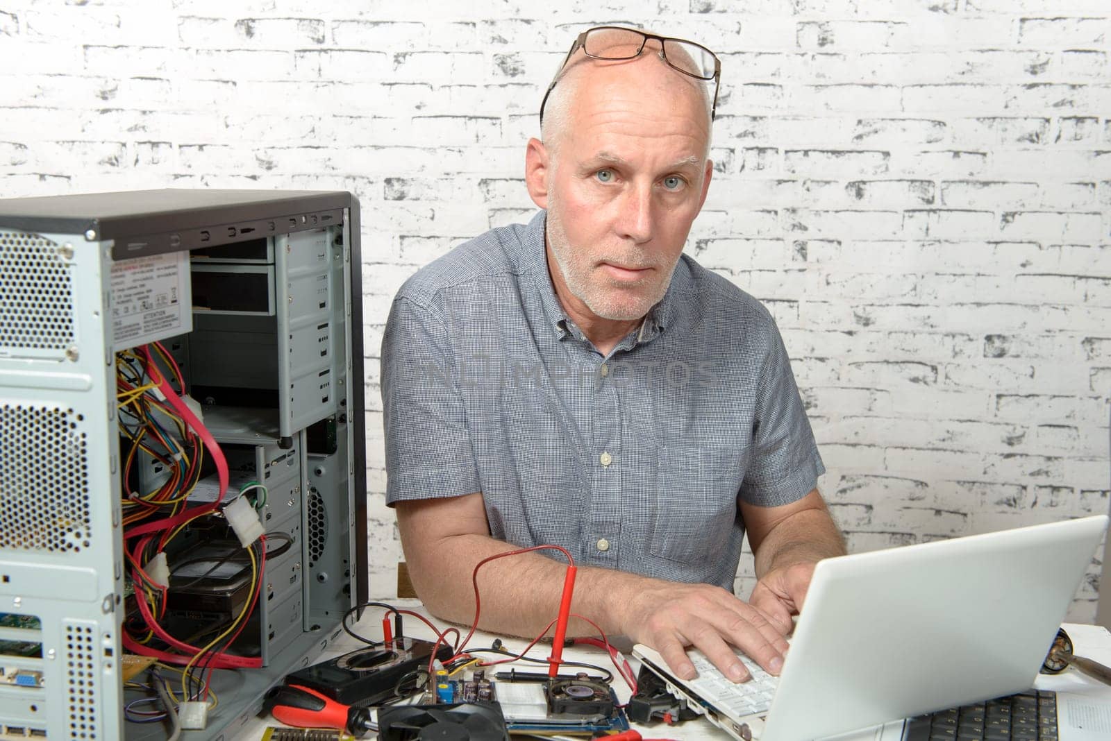 a technician repairing a computer with different tools