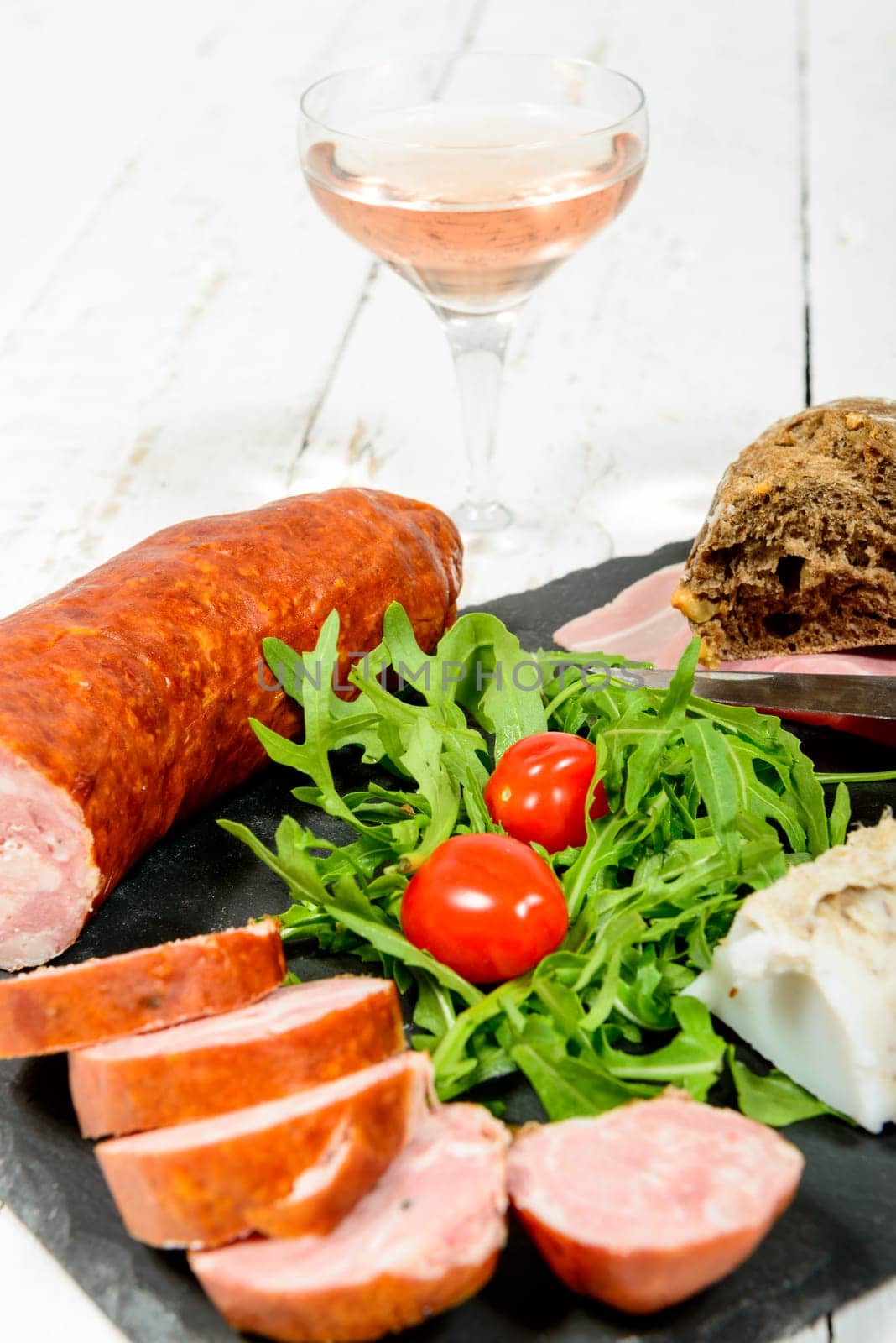 charcuterie plate with wine , bread and tomatoes