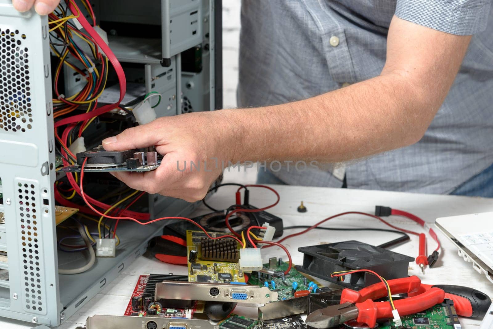 a technician repairing a computer with different tools