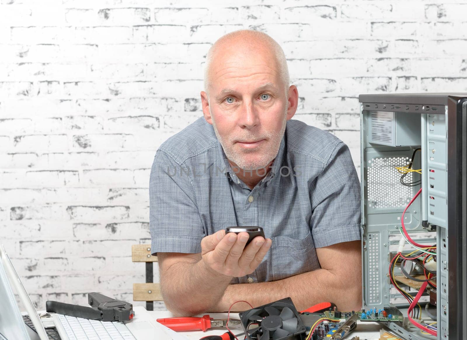 a technician repairing a computer with different tools