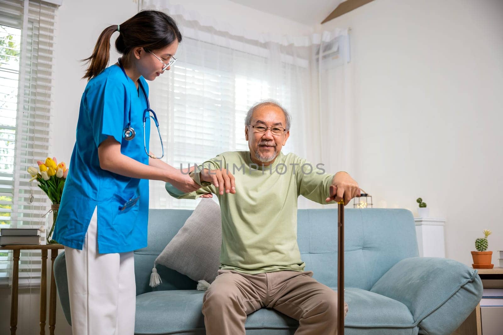 Young woman help support orthopedic patients to get up with walking cane at home, Caring nurse helping supporting senior disabled man to stand up with walking stick, International Day for the Elderly