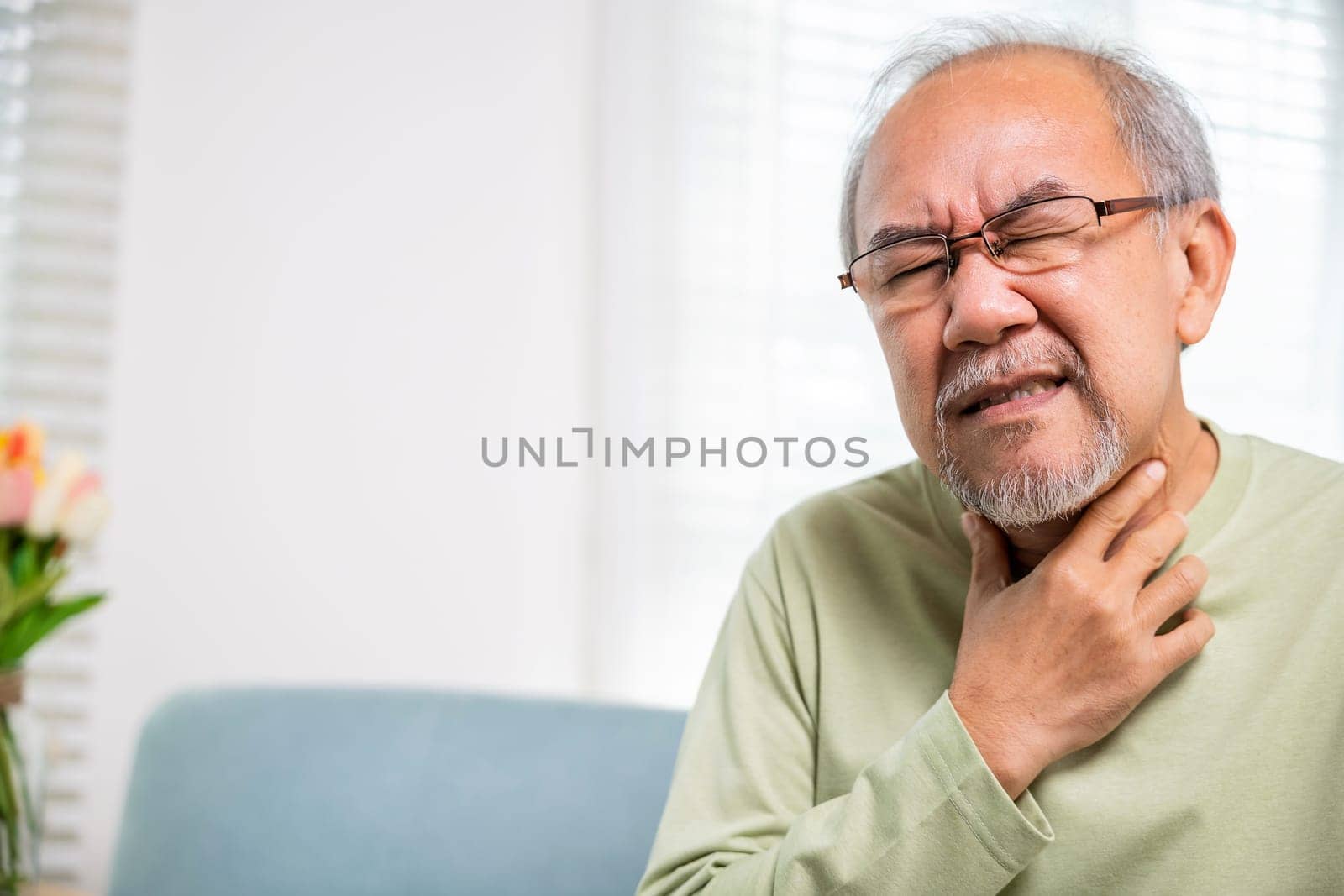 Asian old man painful in the sore throat, retirement senior man feeling pain use hands holding neck, Elderly people have dysphagia due to eating, Health care and medicine concept