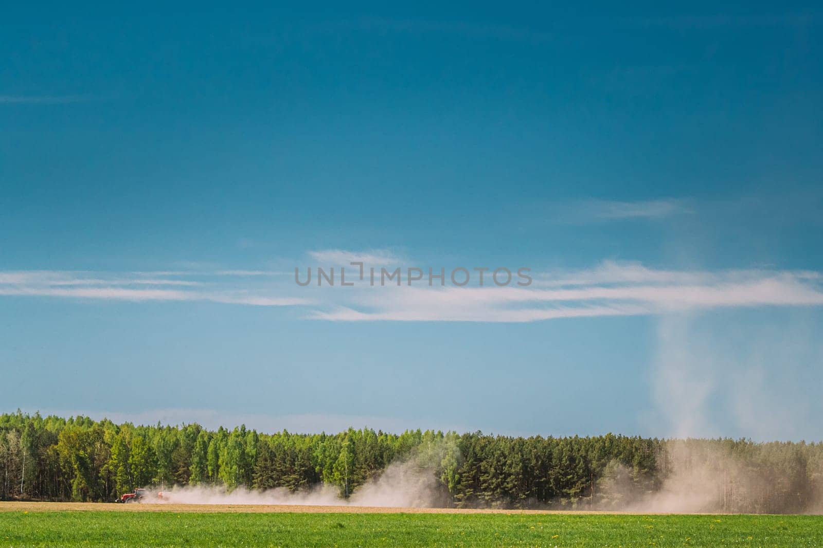 Tractor With Seed Drill Machine Sowing The Seeds For Crops In Spring Season. Beginning Of Agricultural Spring Season. Countryside Rural Field Landscape.