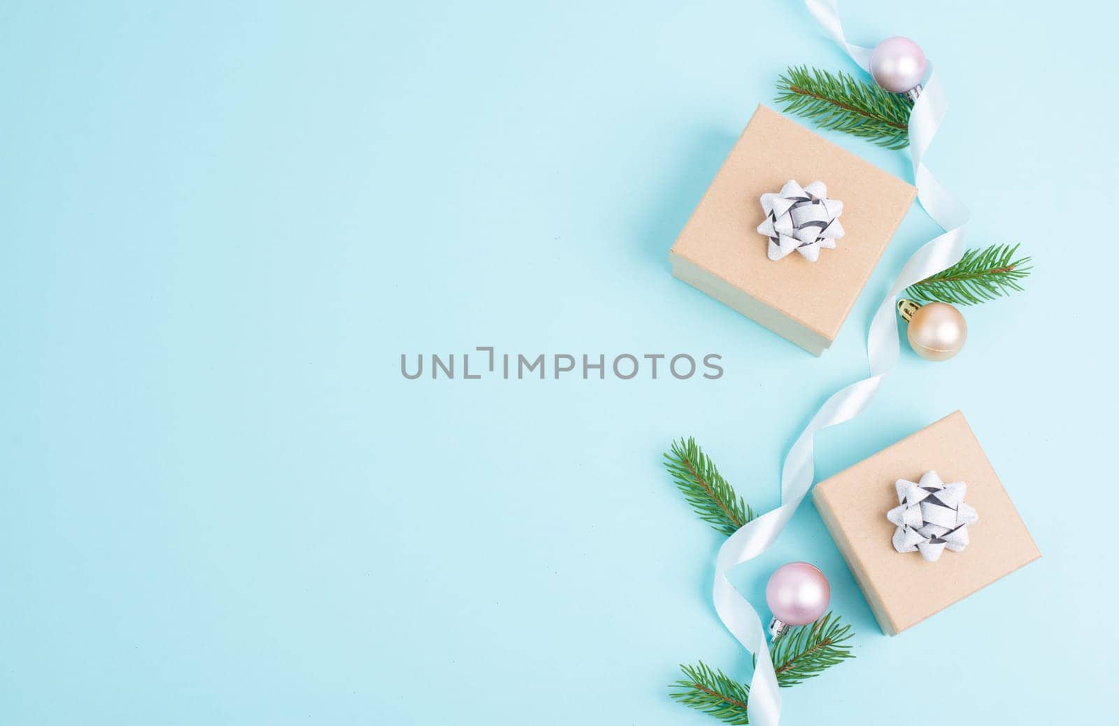 Christmas holiday greeting card with little gift boxes, stars and fir branches, blue background
