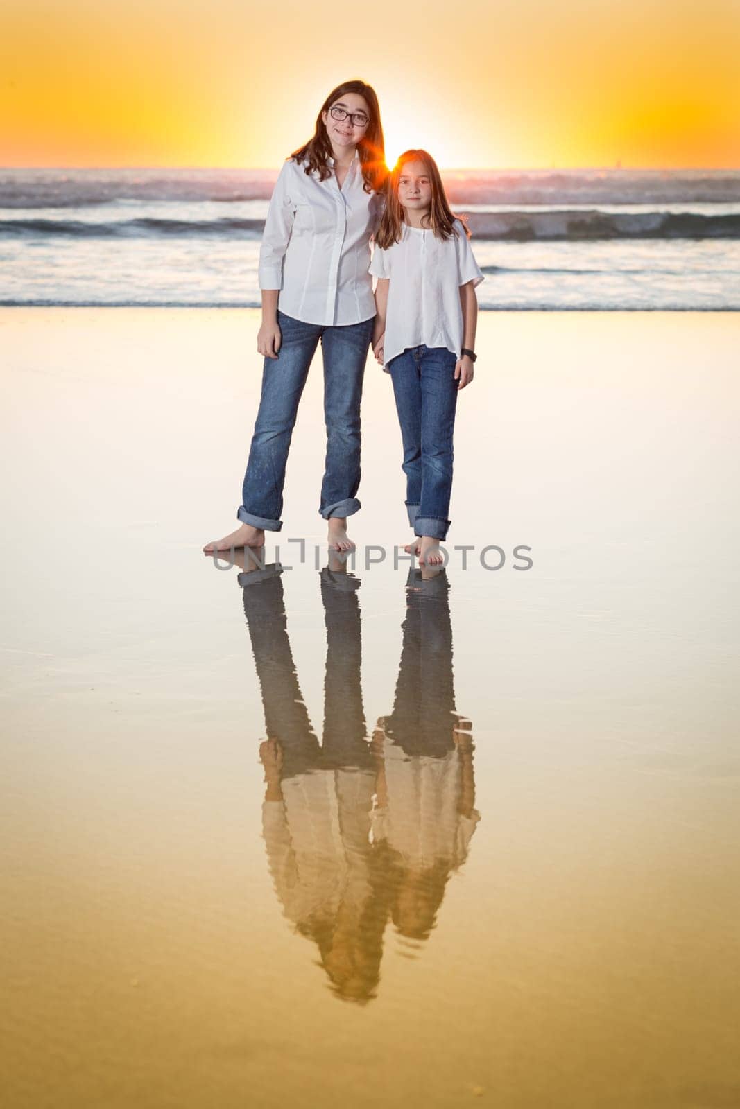 Two Young Sisters Portrait on The Beach.