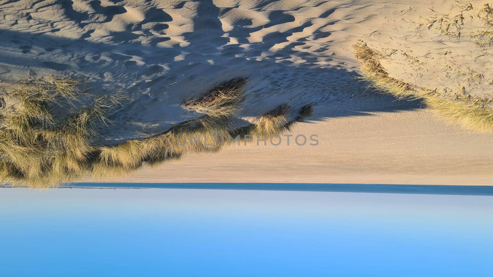 View of the resort of Port Zelande and its surroundings of the lake and dunes under a partly blue sky