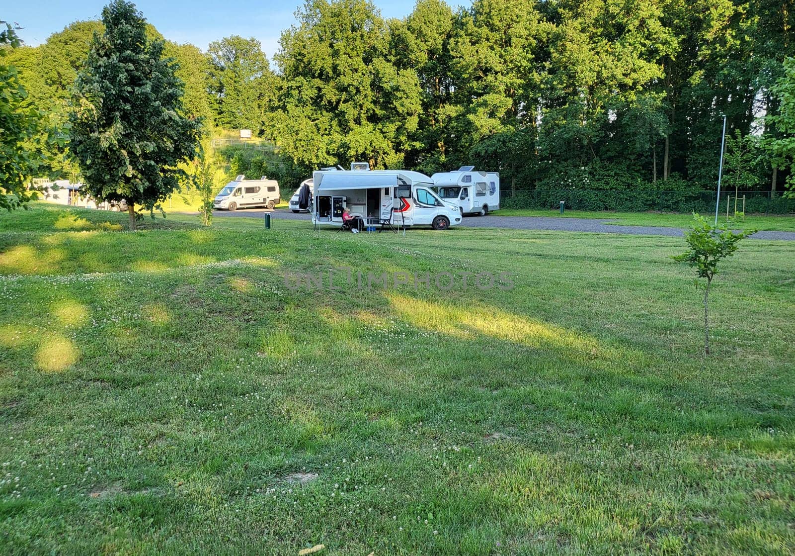 Mobile home with awning and awning and camping table with chairs on the campsite