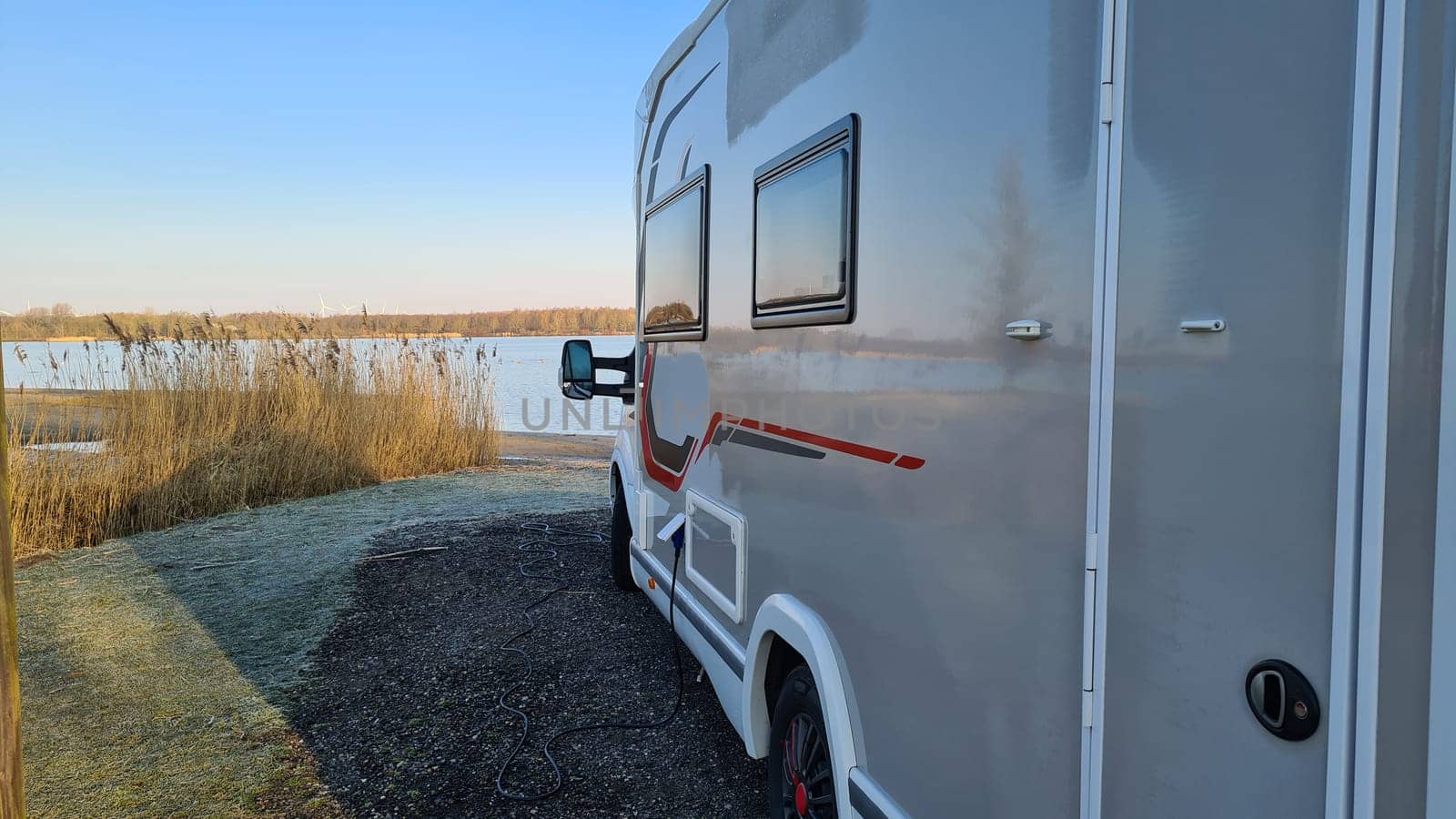 Autumn RV camping. Modern camper van in the late sunny autumn afternoon. Picturesque RV Park.