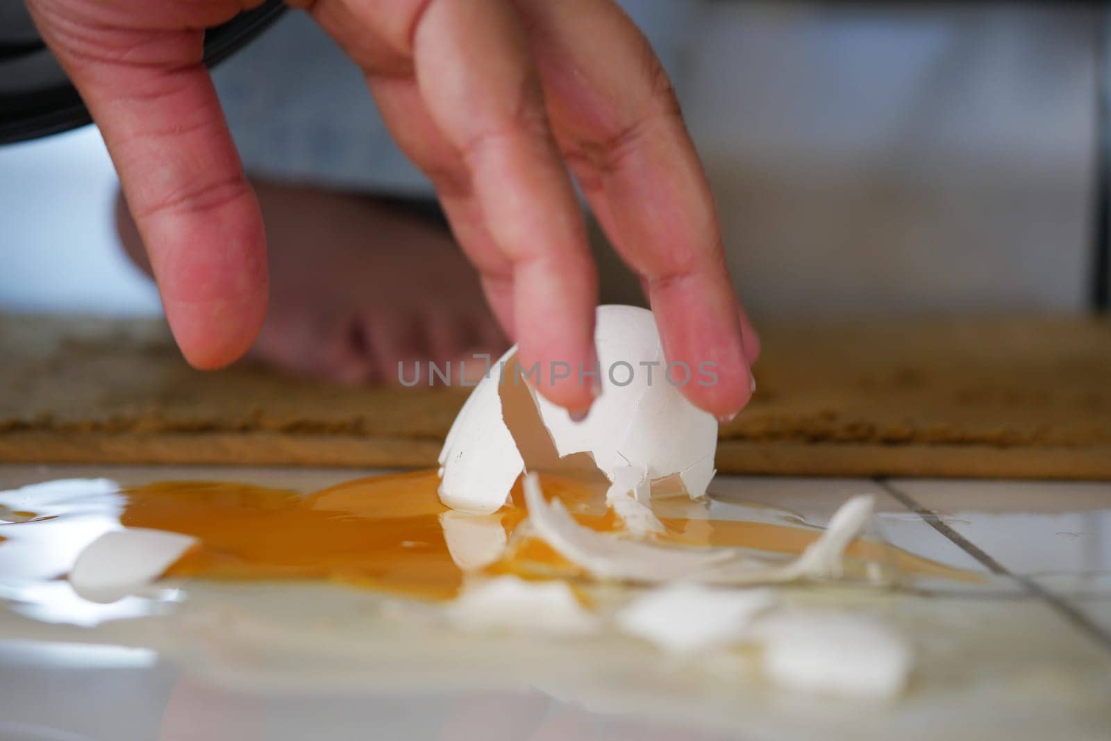 Egg shell pieces and spilled yolk create a mess in the kitchen.