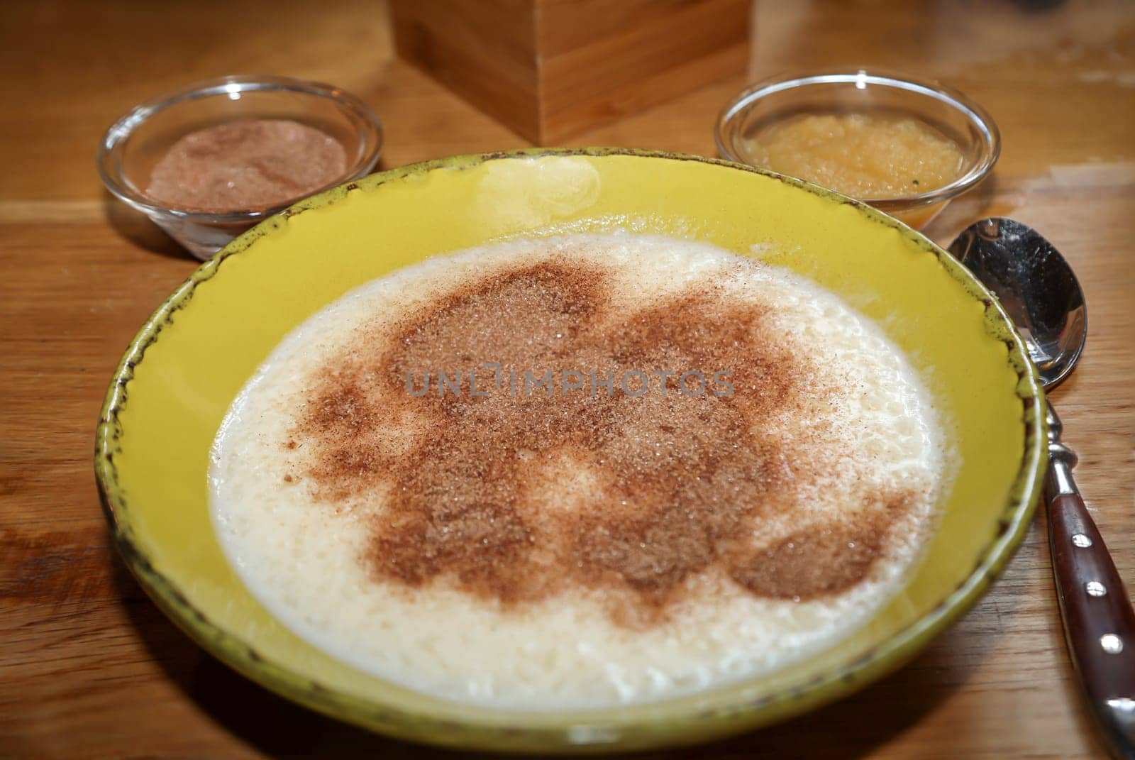 A plate of porridge, applesauce, and cinnamon and sugar.