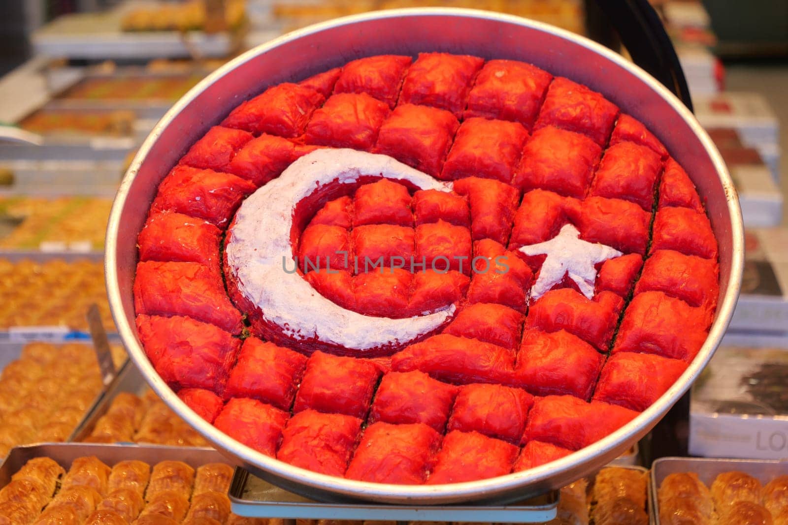 Colorful tray of baklava with Turkey's flag design displayed for sale.