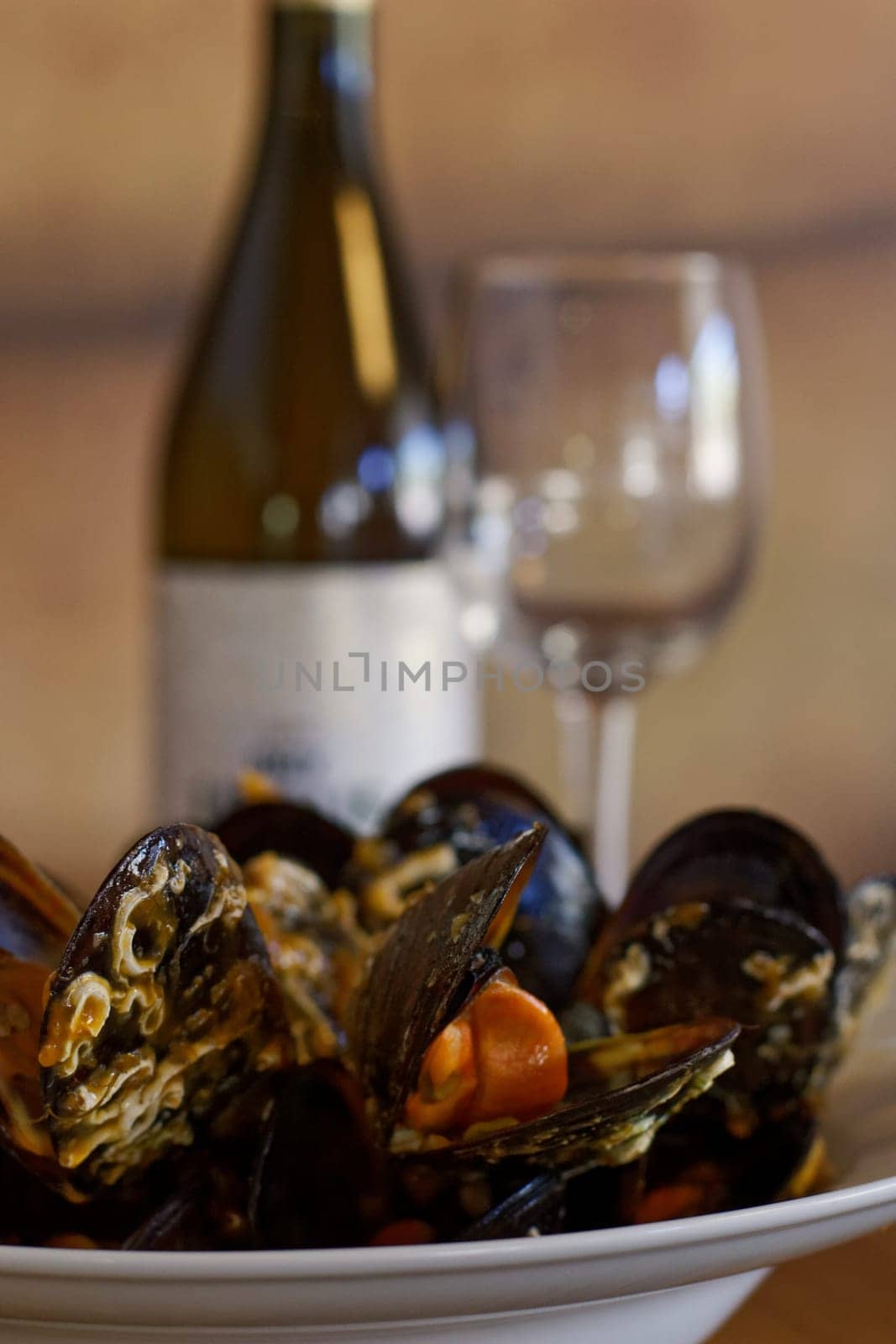 plate of mussels with wine and glass on background