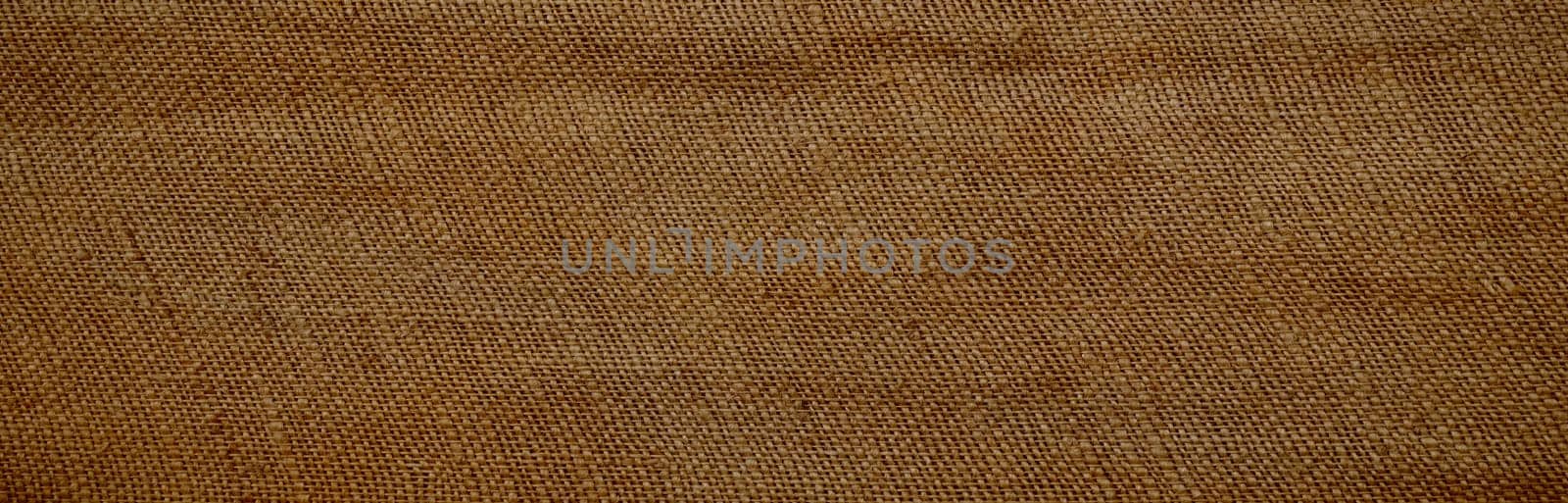 Background of an old brown jutesack in panorama format