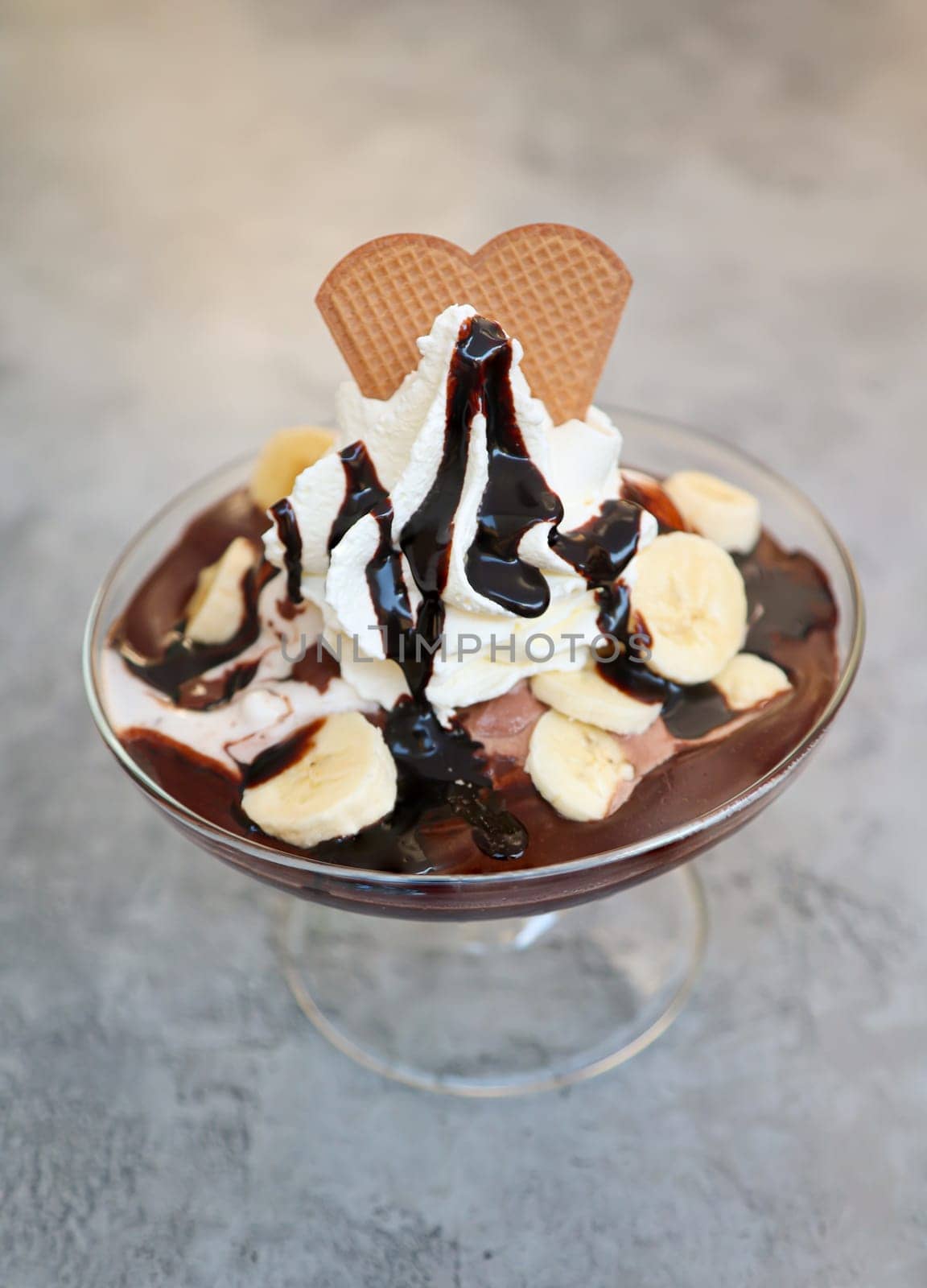 A banana chocolate sundae with whipped cream and chocolate sauce.