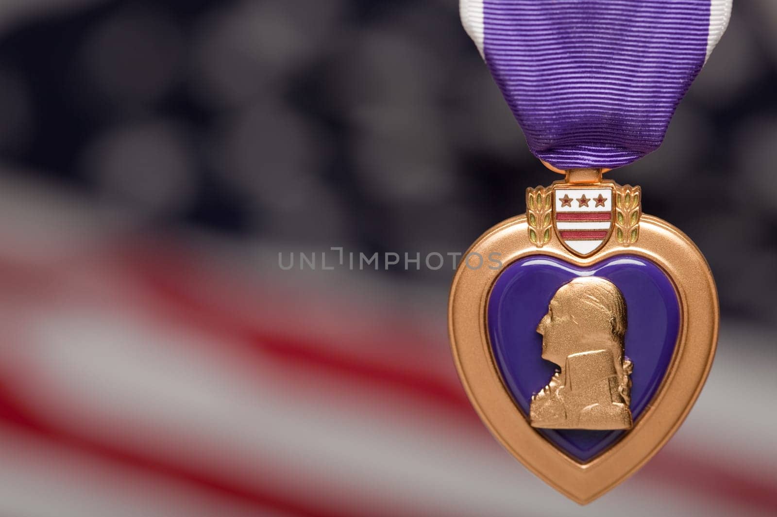 Purple Heart Against a Blurry American Flag.