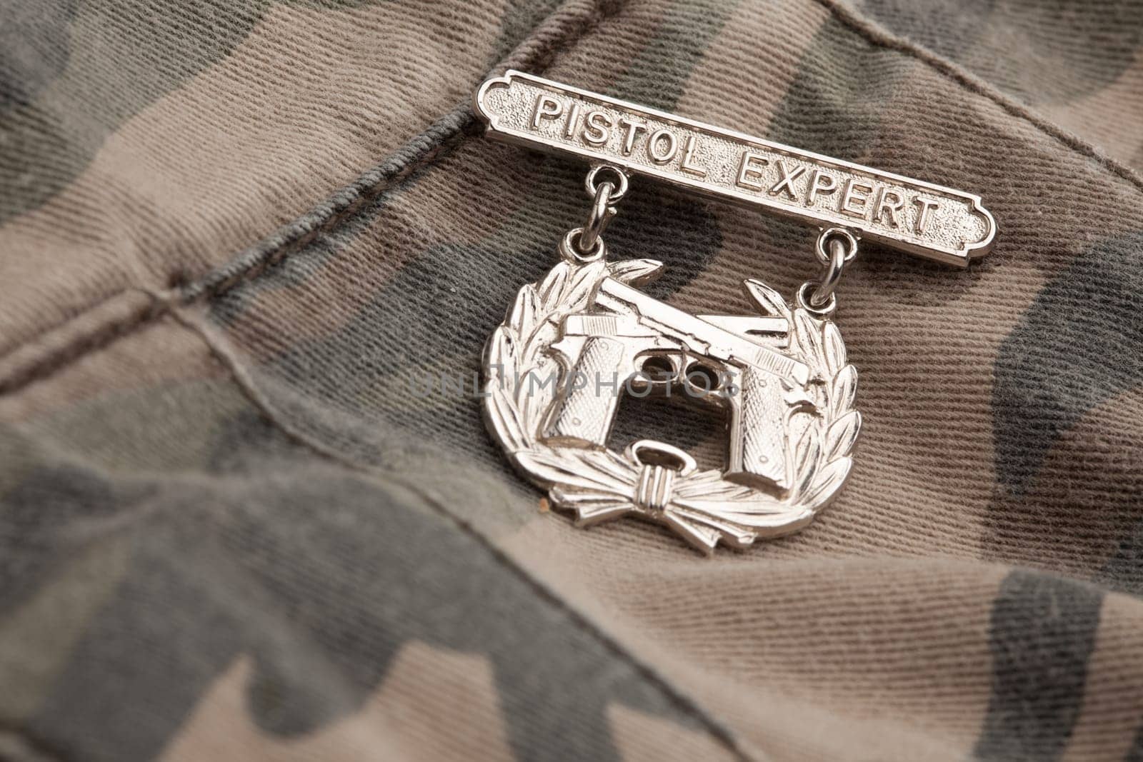 Pistol Expert War Medal on a Camouflage Background.